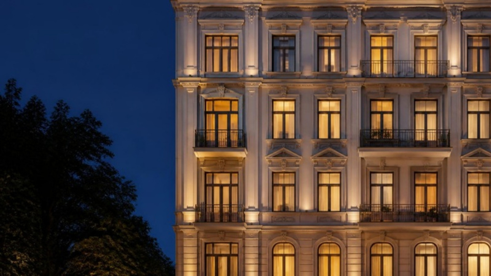 Beleuchtete Altbaufassade in der blauen Stunde