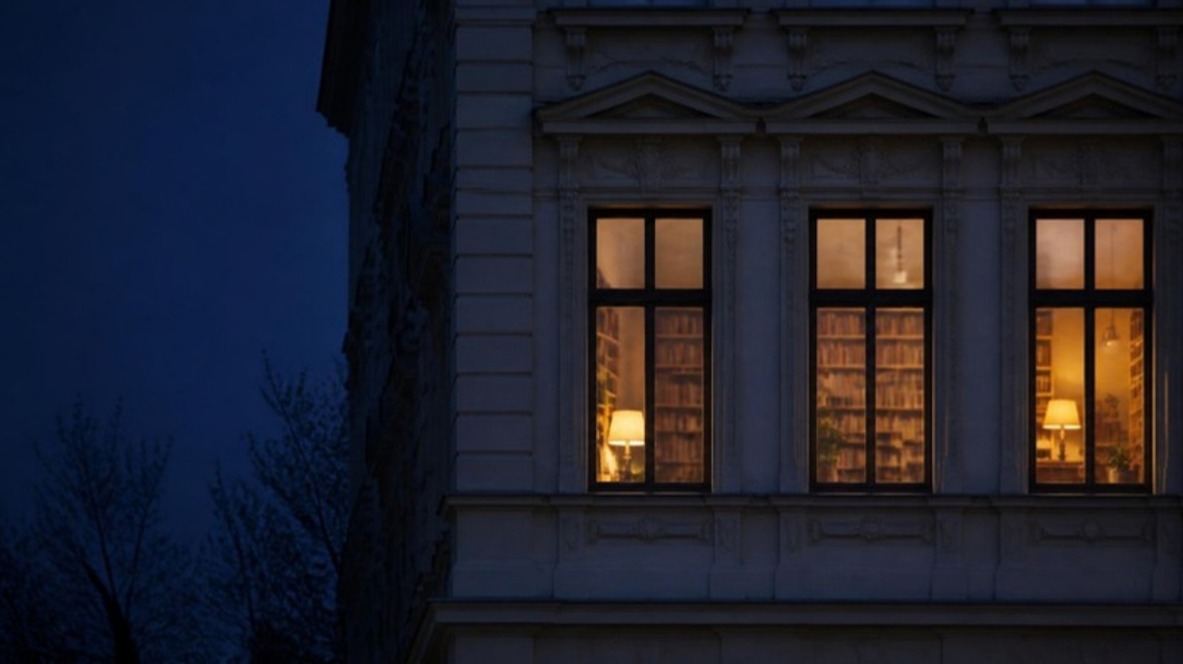 Altbaufenster mit Bücherregalen in der Abenddämmerung
